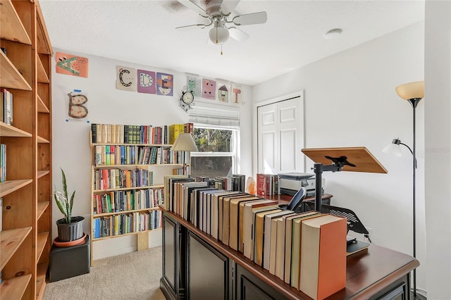 home office featuring ceiling fan, a textured ceiling, and light colored carpet