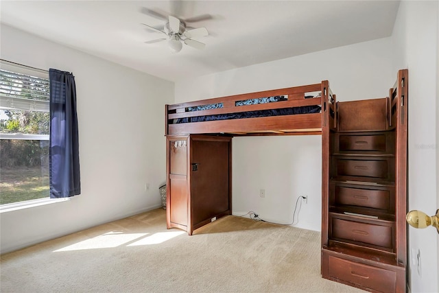 unfurnished bedroom featuring a ceiling fan and light carpet