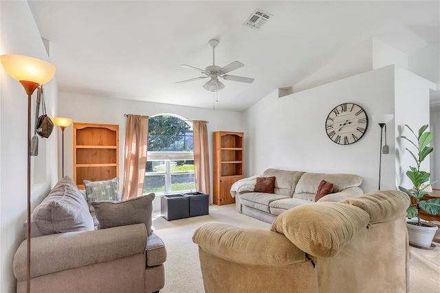 living area with light carpet, vaulted ceiling, visible vents, and a ceiling fan