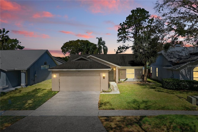 ranch-style home with an attached garage, a yard, driveway, and stucco siding