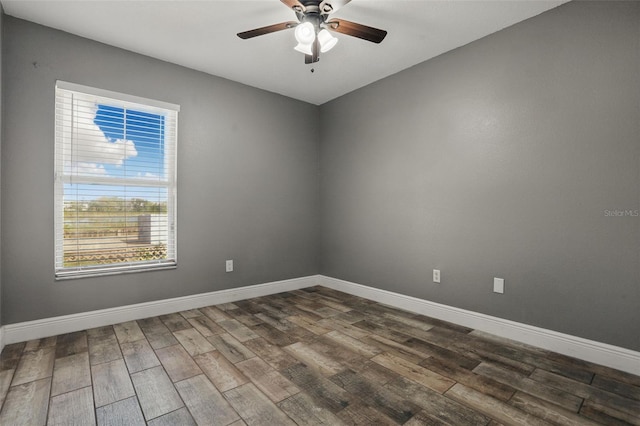 unfurnished room with baseboards and dark wood finished floors