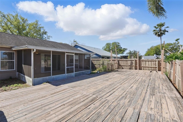 wooden deck featuring a fenced backyard and a sunroom