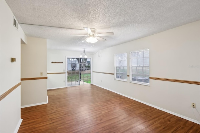 spare room with ceiling fan with notable chandelier, hardwood / wood-style floors, and a textured ceiling