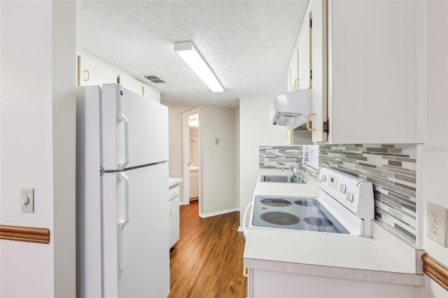 kitchen with white cabinets, white appliances, light hardwood / wood-style floors, and exhaust hood