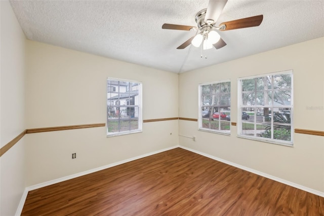 unfurnished room featuring wood-type flooring, a textured ceiling, and plenty of natural light