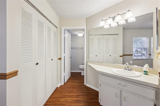 bathroom featuring vanity, a textured ceiling, toilet, and hardwood / wood-style flooring