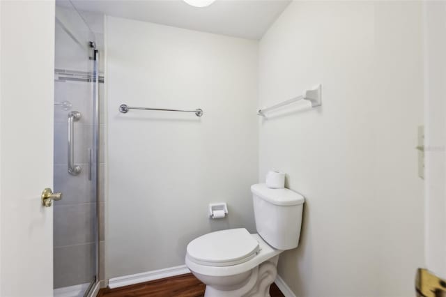 bathroom featuring wood-type flooring, toilet, and walk in shower