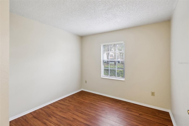 unfurnished room featuring hardwood / wood-style flooring and a textured ceiling