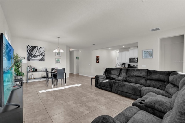 living area featuring light tile patterned floors, baseboards, visible vents, and an inviting chandelier