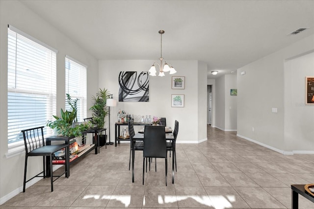 dining area with baseboards, light tile patterned flooring, visible vents, and an inviting chandelier