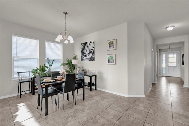 dining area featuring baseboards, a notable chandelier, and light tile patterned flooring