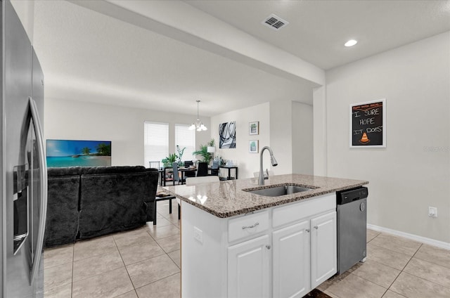 kitchen with decorative light fixtures, a center island with sink, appliances with stainless steel finishes, white cabinetry, and a sink