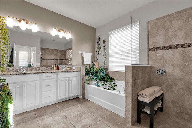 bathroom with double vanity, a sink, a bath, and tile patterned floors