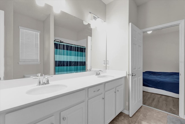 full bath featuring tile patterned flooring, a sink, ensuite bath, and double vanity