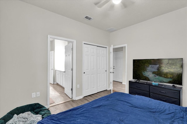 bedroom with baseboards, visible vents, a ceiling fan, wood finished floors, and ensuite bathroom