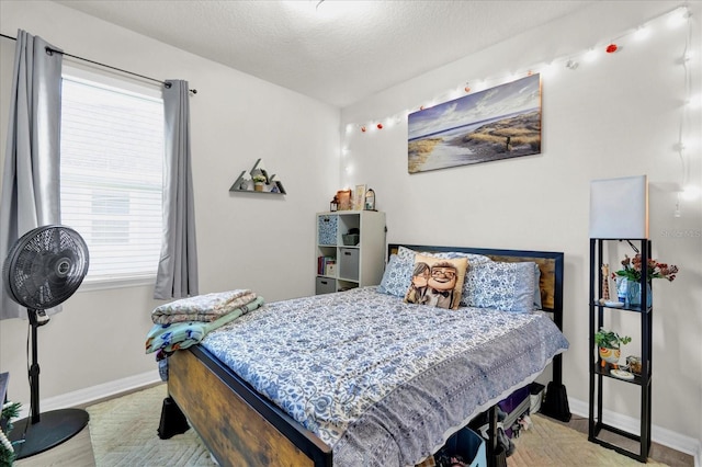 bedroom featuring a textured ceiling and baseboards