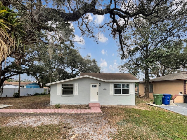 view of front of property featuring a front yard, fence, and stucco siding