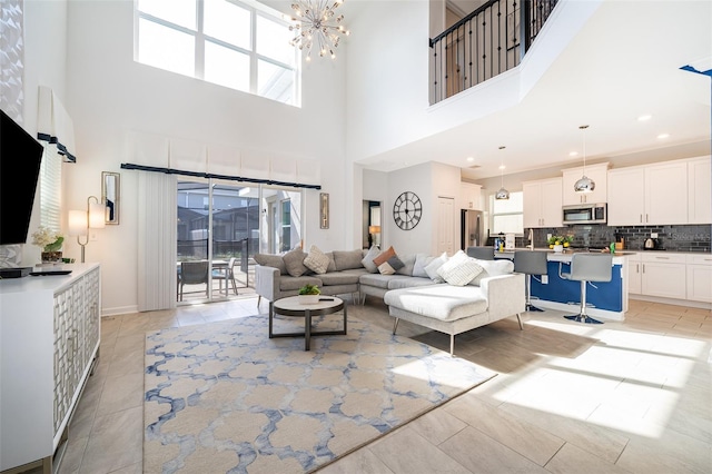 living room with a notable chandelier, light tile patterned floors, and plenty of natural light