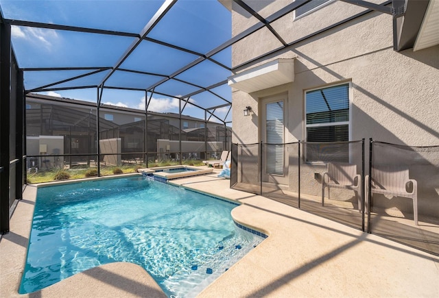 view of pool featuring an in ground hot tub, a patio area, and glass enclosure