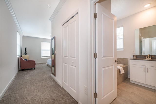 corridor featuring crown molding, sink, and light carpet