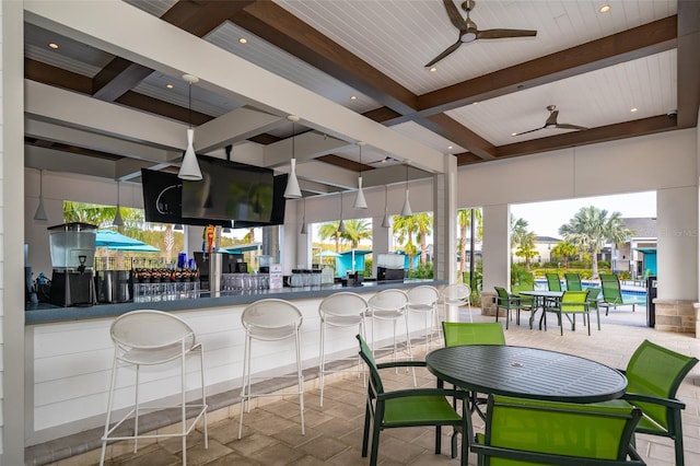 interior space with a bar and ceiling fan