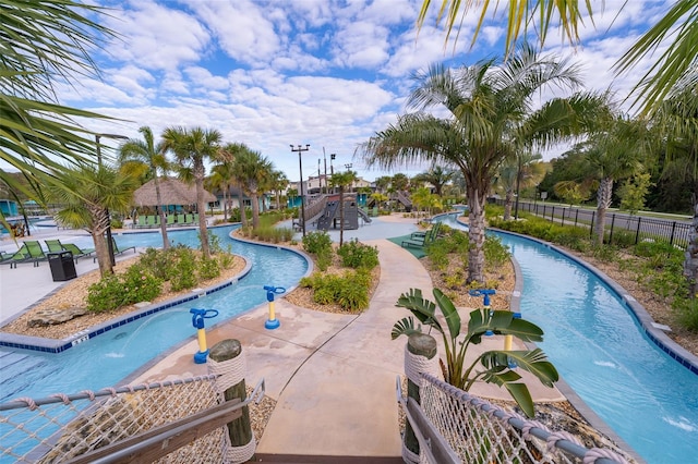 view of pool featuring pool water feature and a playground