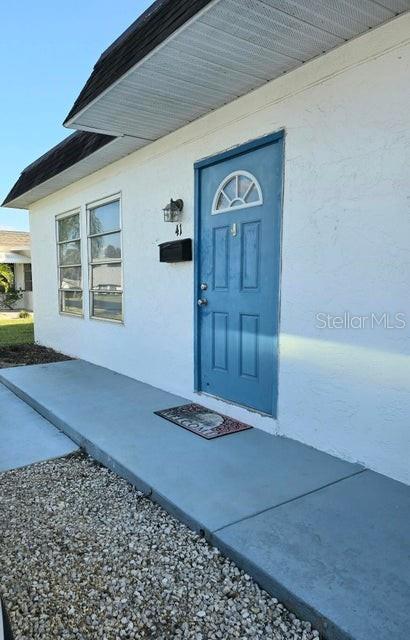 view of exterior entry with a patio area