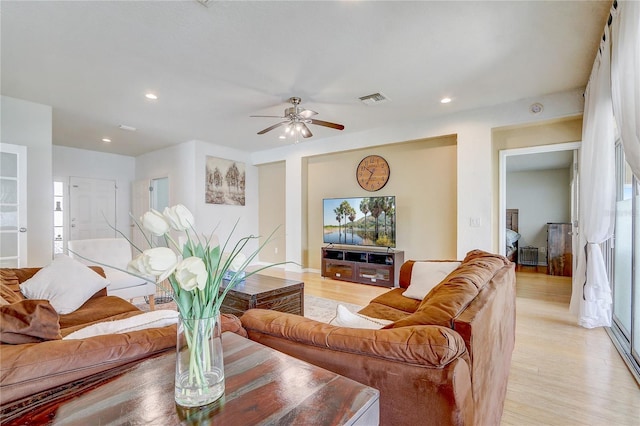 living room with ceiling fan and light hardwood / wood-style flooring