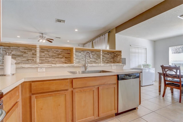 kitchen featuring light tile patterned flooring, stainless steel dishwasher, sink, and a textured ceiling