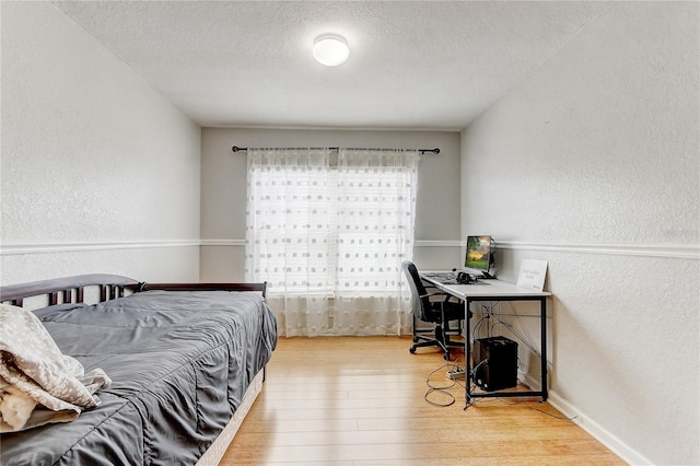 bedroom with hardwood / wood-style flooring and a textured ceiling