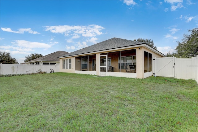 back of house with a yard and a sunroom