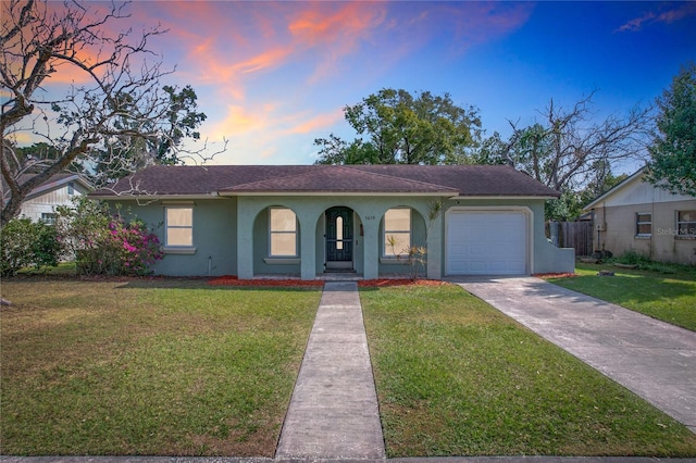 view of front of home with a garage and a lawn