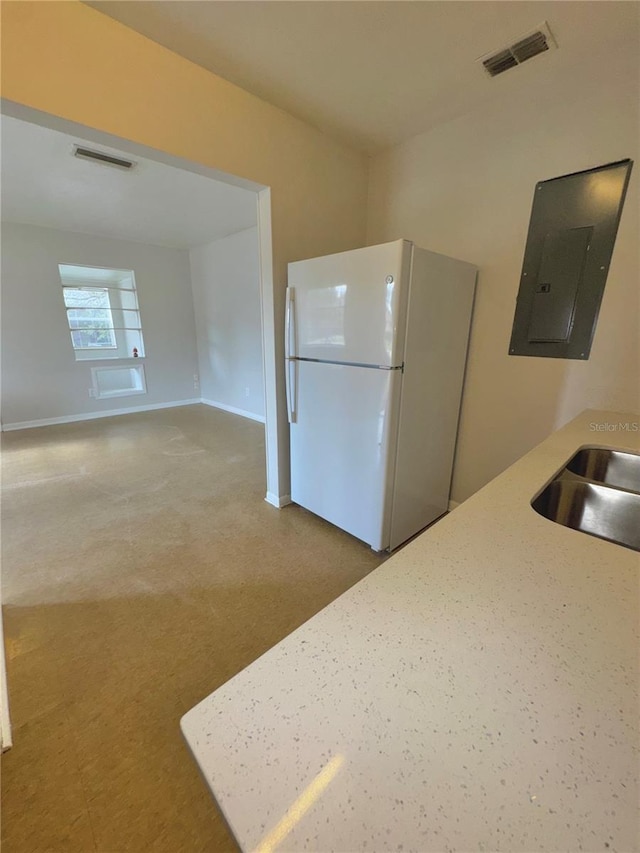 kitchen featuring sink, electric panel, and white fridge