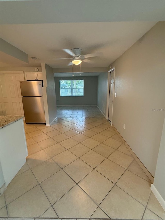 empty room featuring ceiling fan and light tile patterned flooring