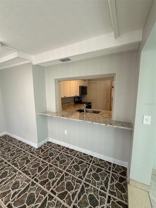 kitchen featuring sink, electric range, beam ceiling, and kitchen peninsula