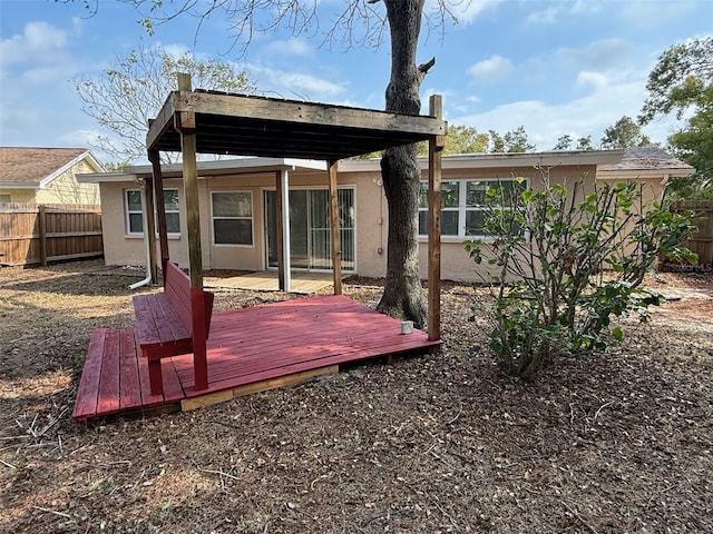 rear view of property featuring a wooden deck