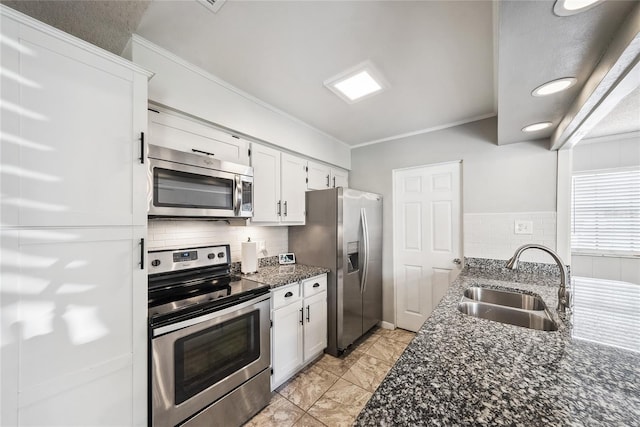 kitchen featuring sink, white cabinets, backsplash, dark stone counters, and stainless steel appliances