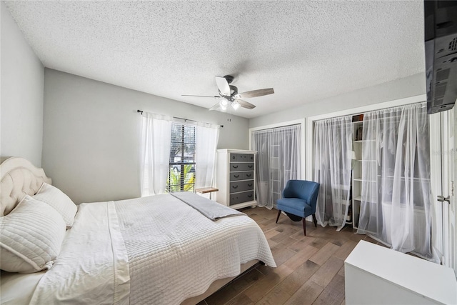 bedroom featuring hardwood / wood-style flooring, a textured ceiling, and ceiling fan