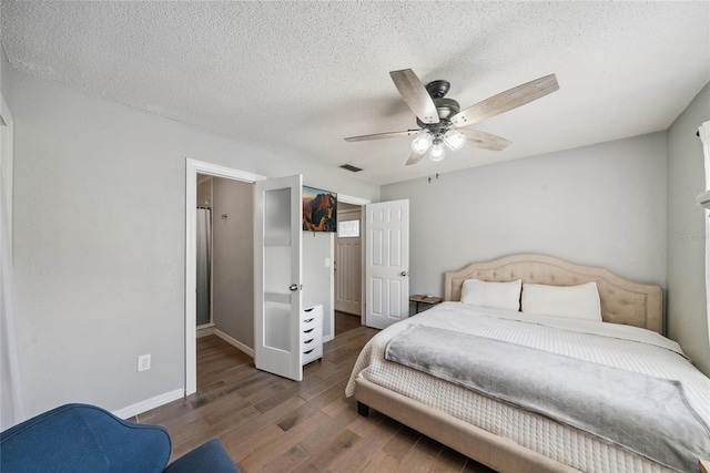 bedroom featuring ceiling fan, dark wood-type flooring, and a textured ceiling