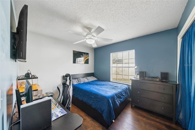 bedroom with dark wood-type flooring, ceiling fan, and a textured ceiling