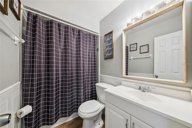 bathroom with vanity, curtained shower, and toilet