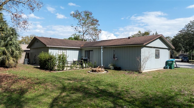 rear view of house featuring cooling unit and a yard