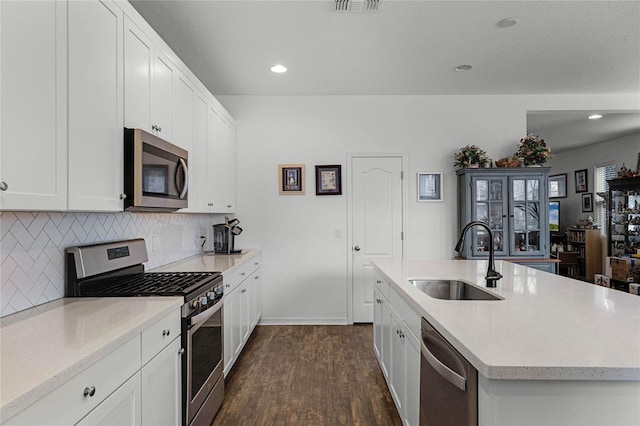 kitchen with a sink, appliances with stainless steel finishes, dark wood-style floors, and white cabinets