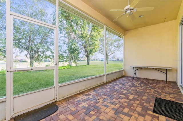 unfurnished sunroom with ceiling fan