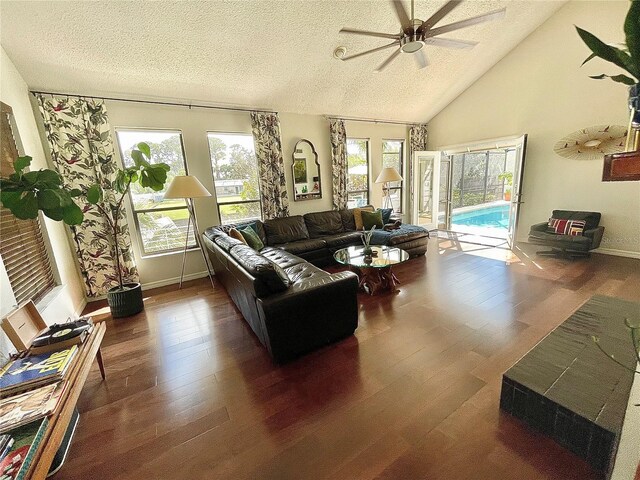 living area with high vaulted ceiling, a textured ceiling, a ceiling fan, and wood finished floors