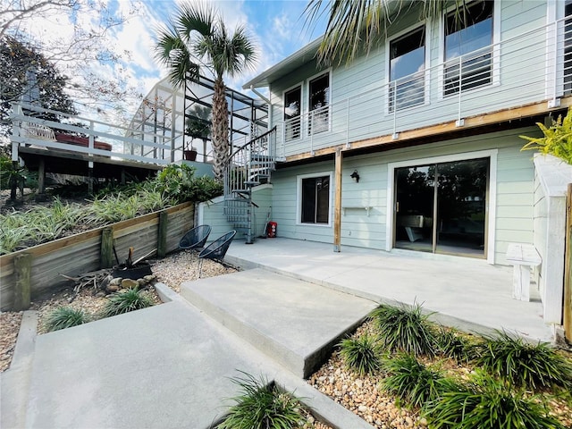 rear view of house featuring stairs and a patio