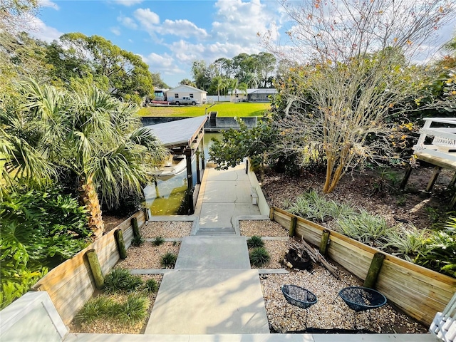 view of community with a dock and fence