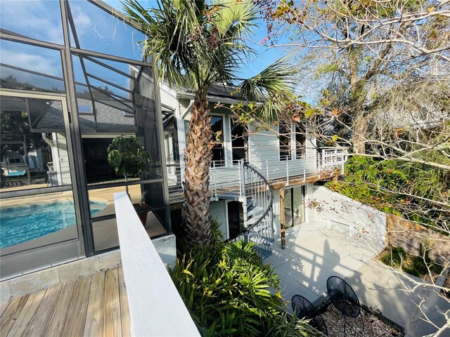 back of property with glass enclosure and an outdoor pool