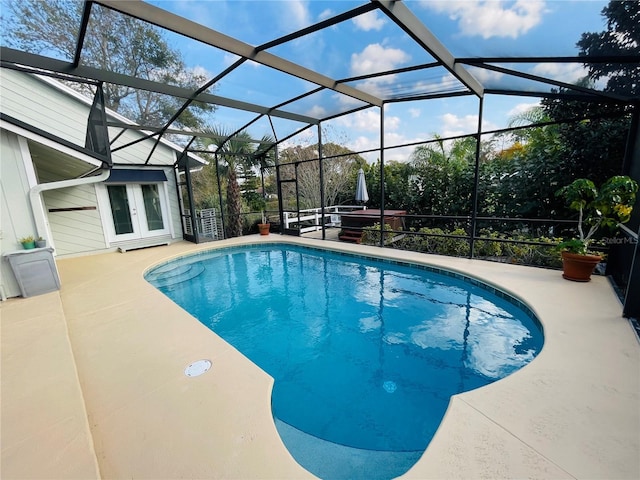 outdoor pool featuring a patio, french doors, and glass enclosure