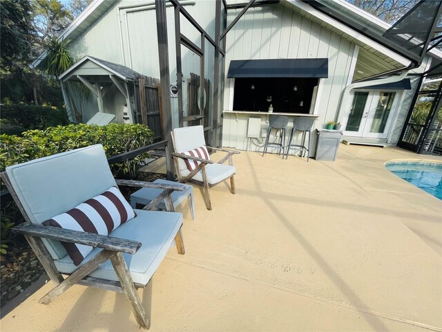 view of patio / terrace featuring french doors, an outdoor pool, and outdoor dry bar